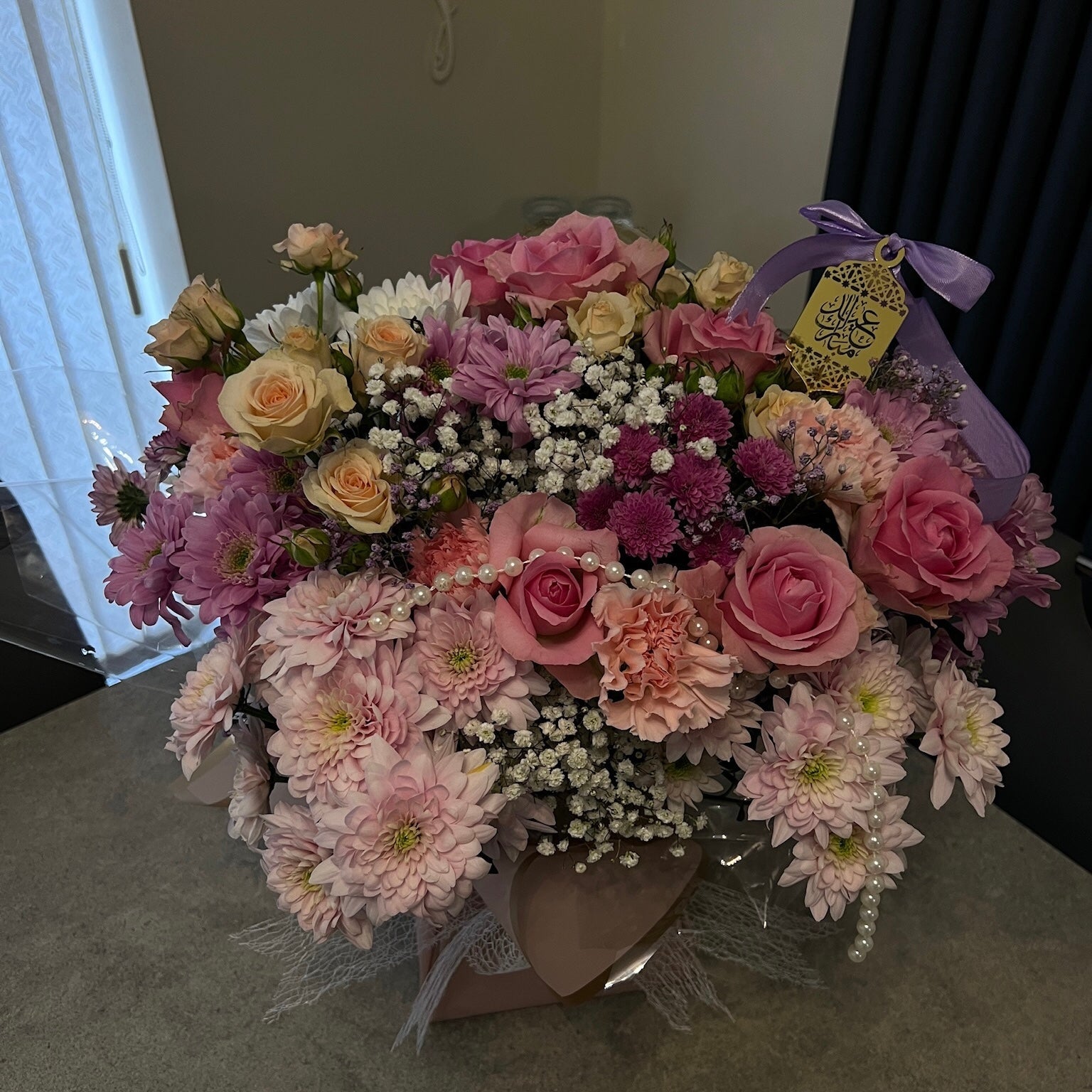 Bouquet of flowers with a purple ribbon on a table