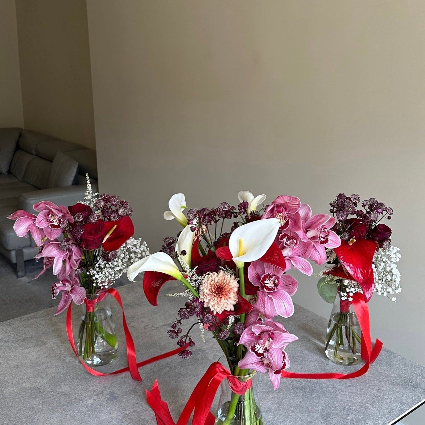 Two floral arrangements with pink and red flowers on a table.