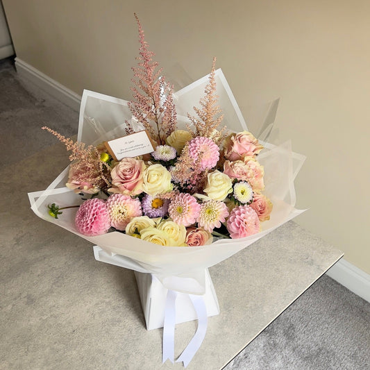 Bouquet of flowers with a card on a neutral background

