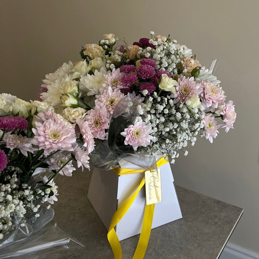 Bouquet of flowers with a yellow ribbon on a neutral background