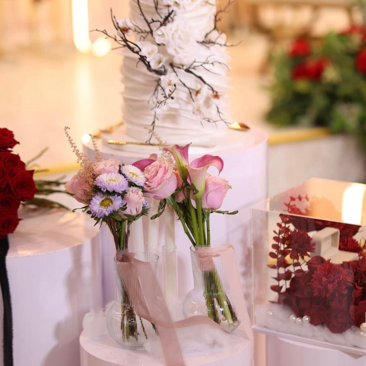 Decorative table setting with flowers and candles on a white surface