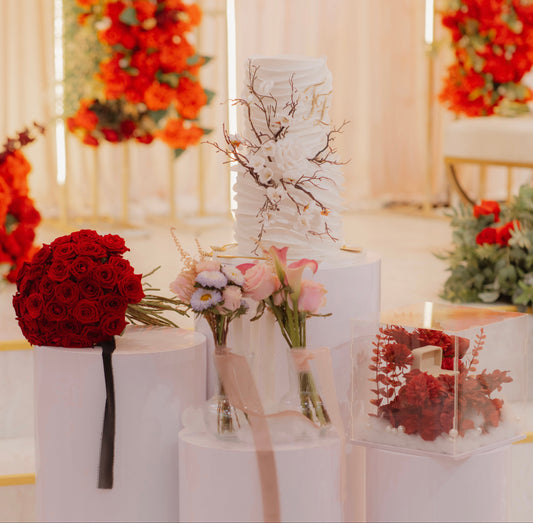 Wedding cake with floral decorations on a table in a decorated room.